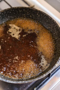 Caramel en train de cuire dans une poêle sur une cuisinière.