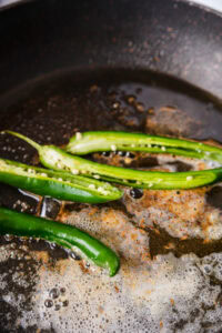 Butter Chicken - Ajouter les graines de cumin, les piments verts et la purée d'oignon rôti puis faire revenir 1 minute.