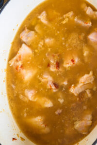 Gaeng Hang Lay - Verser le reste de l’eau petit à petit à mesure que le liquide réduit; assaisonner avec le sel, la sauce soja noire, le sucre de palme et le jus de tamarin.