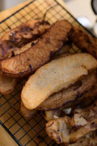Beignets de banane (Bánh Chuối Chiên) - Tremper chaque morceau de banane dans la pâte pour l’enrober uniformément puis le plonger dans l’huile chaude.