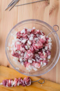 Brochettes d'agneau du Xinjiang - Enfiler la viande sur des brochettes métalliques pour former les brochettes.