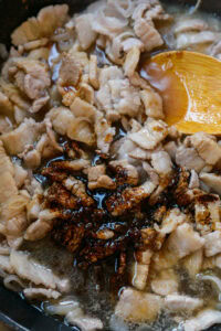 Khao Kluk Kapi - Découvrir et ajouter le sucre, les sauces soja et poursuivre à feu doux jusqu’à réduction en glaçage sirupeux.