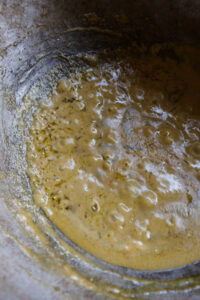 Mélange jaune mousseux en train de cuire dans une poêle ou un wok.