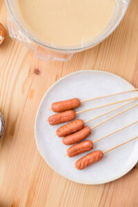 Pong Neng - Enfiler les saucisses sur le bout des brochettes.