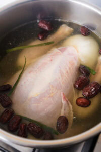 Nurungji Baeksuk - Plonger le poulet préparé dans le bouillon.