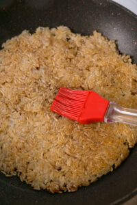 Riz coréen grillé (Nurungji) - Après 5 minutes, retourner le riz croustillant, le badigeonner de glaçage, puis retourner à nouveau pour badigeonner l'autre face