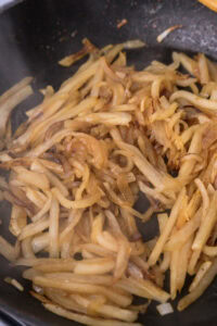 Bò Bía - Chauffer une poêle avec un peu d’huile de cuisson. Faire revenir les échalotes jusqu’à parfumées. Ajouter le jicama en julienne. Faire sauter le jicama jusqu’à cuit. Assaisonner le jicama avec la sauce huître, le hạt nêm et le poivre. Poursuivre la cuisson brièvement puis retirer du feu. Laisser refroidir le jicama sauté.