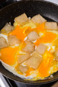 Bột chiên croustillant - Frire la pâte : Rincer la ciboule. Émincer finement la ciboule. Chauffer l’huile ou le saindoux dans une poêle. Faire frire les morceaux à feu moyen. Retourner pour dorer les deux faces. Retirer les morceaux. Laisser refroidir les morceaux. Remettre les morceaux dans la poêle. Passer à feu vif. Casser les œufs sur les morceaux. Parsemer de ciboule. Retourner pour cuire l’œuf. Déposer sur du papier absorbant.