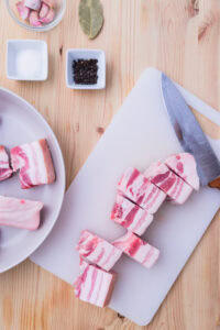 Bagnet - Rincer la poitrine de porc, la couper en gros morceaux et la mettre dans une grande marmite.