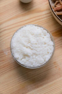Bol de riz blanc cuit sur une table en bois.