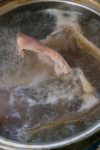 Morceaux de viande bouillant dans une casserole d’eau.