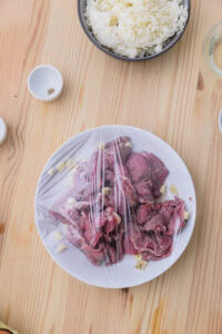 Tapsilog - Mélanger le bœuf avec le vinaigre, l'ail de la marinade, le sel et le poivre, ajouter le sucre brun si désiré, puis couvrir et laisser mariner au réfrigérateur toute une nuit ou plus.