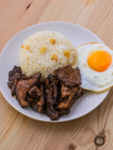 Tapsilog - Servir la tapa, le sinangag et les œufs dans une assiette, avec un sawsawan de vinaigre mélangé à un peu d'ail, de sel et de piment.