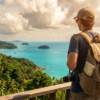 Homme avec sac à dos admirant une vue sur la mer et des îles depuis un belvédère en hauteur.