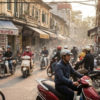 Circulation dense de scooters dans une rue animée bordée de commerces au Vietnam.