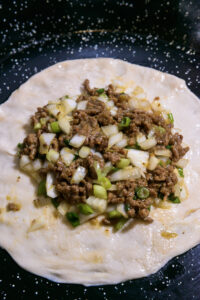 Martabak telur - Finition: Verser le mélange au centre de la pâte.