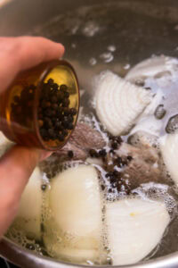 Recette de bulalo - Quand le bouillon est clair, ajouter les grains de poivre, l’oignon et le patis.