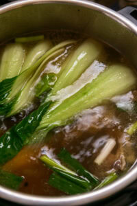 Recette de bulalo - Ajouter le pak choy et couper le feu après 2 à 3 minutes.