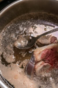 Recette de bulalo - Écumer et retirer l’huile qui remonte à la surface.