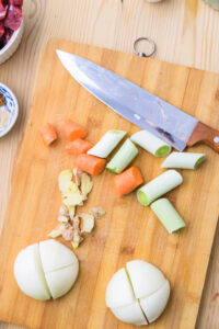 bifu kare - Couper l'oignon, la carotte et le poireau en gros morceaux, puis les ajouter avec les pelures de gingembre.