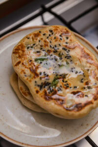 Cheese Naan - Retirer du feu et badigeonner avec 1 cuillère à café de beurre.