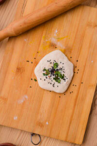 Cheese Naan - Aplatir légèrement et parsemer de graines de sésame noir et de coriandre.