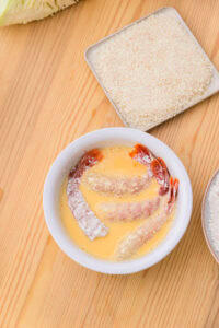 Ebi fry - Recette authentique - Paner: Passer la chair dans le mélange d'oeuf et tremper très légèrement la carapace de la queue, puis laisser égoutter.