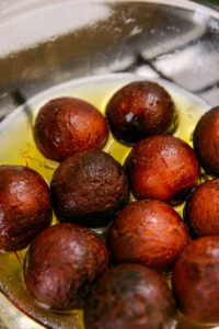 Gulab Jamun - Sortir les boules de l'huile et les plonger immédiatement dans le sirop refroidi pour qu'elles l'absorbent.