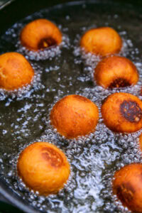 Gulab Jamun - Plonger les boules dans l'huile à feu doux et laisser frire lentement jusqu'à ce qu'elles soient dorées.
