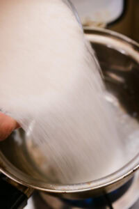 Gulab Jamun - Mélanger le sucre et l'eau dans une casserole et chauffer jusqu'à ce que le sucre soit complètement dissous.