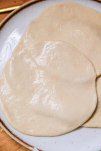 Naan - Badigeonner un peu d'eau sur toute la surface supérieure du pain (l'eau permet au pain d'adhérer à la poêle pendant la cuisson)