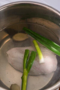 Poulet bang bang - Recette authentique - Ajouter le blanc de poulet, la ciboule et le gingembre.