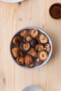 Authentique Chirashi - Réhydrater les shiitake dans de l’eau tiède, retirer les pieds, puis les cuire avec les assaisonnements indiqués.