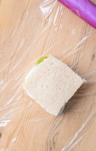 Authentique Fruit Sando - Version fruits mélangés: Étaler une fine couche de crème sur une deuxième tranche de pain, refermer, envelopper fermement; ne pas tracer de ligne (coupe diagonale).