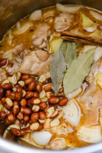 Curry massaman - Ajouter les pommes de terre, les petits oignons, les cacahuètes, les feuilles de laurier, les gousses de cardamome et le bâton de cannelle.