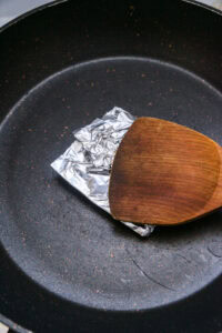Curry massaman - Envelopper la pâte de crevettes dans une feuille de bananier ou du papier aluminium, puis la griller ou la saisir à la poêle jusqu’à ce qu’elle soit parfumée.
