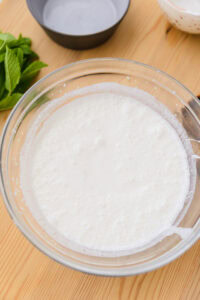 Lassi - Mélanger le tout au yaourt avec une baratte (madhani) ou un blender jusqu’à obtenir de la mousse.