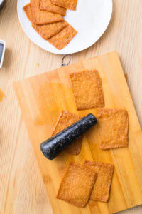 Authentique Inari Sushi - Rouler une baguette (ou un objet anguleux) sur les feuilles d’aburaage pour casser les fibres et faciliter l’ouverture.