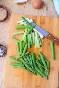 Authentique Pajeon - Préparer les légumes : Parer les ciboules, les laver soigneusement, puis les couper en tronçons d’environ 10 cm. Couper le piment vert et le piment rouge en biais, en morceaux d’environ 2 cm de long et 3 mm d’épaisseur.