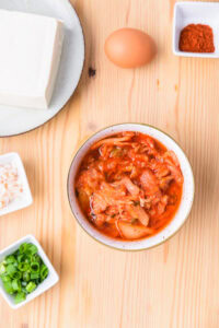 Authentique sundubu jjigae - Mélanger le kimchi avec le jus de kimchi.