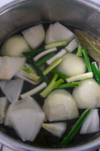 Boeuf pares - Quand l'eau est claire et sans écume, ajouter l'oignon, l'ail, les grains de poivre, les feuilles de laurier et 1 cuillère à soupe de sel.