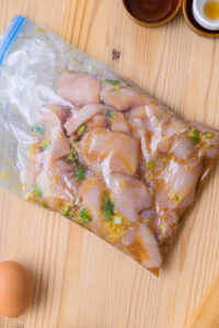 Toriten d’Oita - Mettre le poulet dans un sac plastique avec les ingrédients de la marinade et l'oignon vert, puis laisser reposer 20 à 30 minutes.
