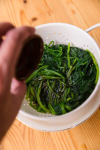 Hōrensō gomaae - Les arroser d'un peu de sauce soja, puis les presser de nouveau (shōyu-arai).