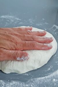 Baguette sans gluten sans pétrissage - Dégaze la pâte avec les mains mouillées sur un plan de travail légèrement fariné.