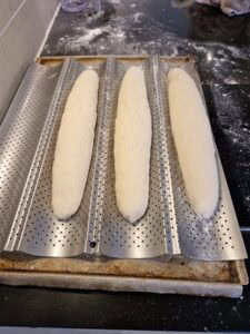 Baguette sans gluten sans pétrissage - Transfère la pâte façonnée sur une plaque à baguettes légèrement farinée avec de la farine sans gluten.
