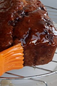 Banana bread chocolat sans gluten - Nappe le banana bread chocolat sans gluten tout juste cuit avec le nappage transparent aux fruits tiède et parsème de pépites de chocolat ou d’éclats de cacao. C’est facultatif. Saute cette étape si ce n’est pas nécessaire.