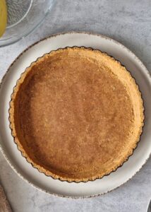 Banoffee pie vegan à la ganache café (sans gluten) - Presse le mélange de miettes dans le fond et sur les côtés du moule à tarte en l’étalant uniformément sur la base et les côtés.