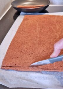 Bûche sans gluten chocolat et châtaigne - Laisse refroidir la plaque de génoise. Coupe les bords secs de la génoise avant utilisation.