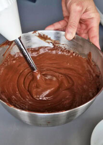 Bûche sans gluten chocolat et châtaigne - Mélange la moitié de la crème pâtissière chaude avec les pépites de chocolat, puis fouette énergiquement jusqu’à ce que le chocolat fonde et forme une crème au chocolat. Mixe au mixeur plongeant pour lisser la crème pâtissière au chocolat.