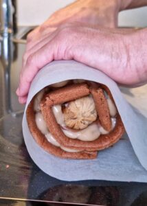 Bûche sans gluten chocolat et châtaigne - Commence à rouler en gardant une certaine tension dans le papier pour soutenir le rouleau sur toute sa longueur, et aide-toi de tes doigts aux extrémités pour faire le premier pli. Soulève le papier cuisson vers le haut, puis vers l’avant pour rouler la génoise, en utilisant le papier pour appuyer doucement dessus et garder un rouleau bien serré. Garde la soudure vers le bas.